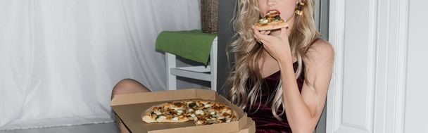 καλλιεργημένη άποψη της νεαρής ξανθιάς γυναίκα τρώει πίτσα, οριζόντια εικόνα - Φωτογραφία, εικόνα