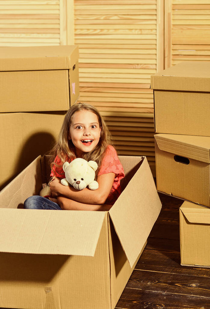 Right Around the Corner. happy child cardboard box. Moving concept. new apartment. Cardboard boxes - moving to new house. happy little girl with toy. purchase of new habitation - Foto, afbeelding