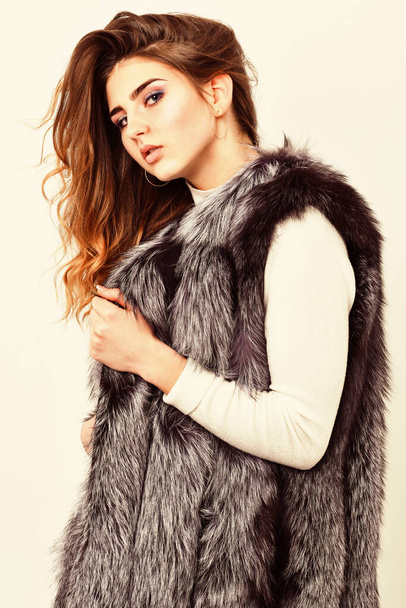 Silver fur vest fashion clothing. Boutique selling fur. Girl makeup face long hairstyle wear fur vest white background. Luxury fur accessory. Fashion trend concept. Winter fashionable wardrobe - Fotó, kép