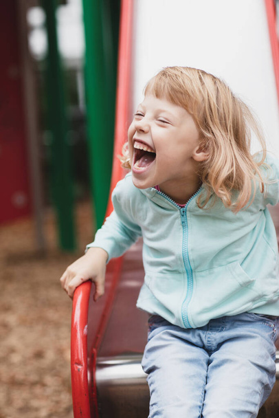 Piccola ragazza disabile gioca nel parco giochi - Foto, immagini