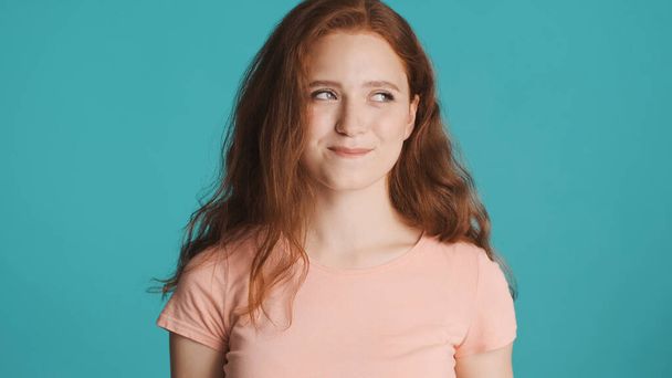 Portrait d'attrayant rousse rusée fille regardant slyly loin sur fond coloré - Photo, image
