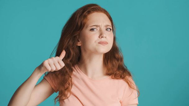 Confident redhead girl threatening on camera over colorful background. You in deep trouble expression - Photo, Image