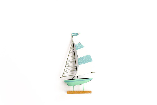 Barca giocattolo in miniatura su sfondo bianco. Posa piatta, vista dall'alto - Foto, immagini