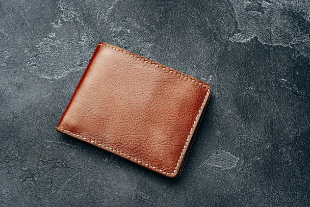 New brown leather wallet on dark background - Fotoğraf, Görsel