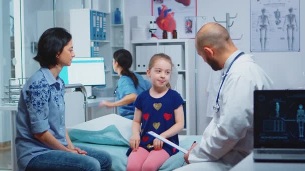 Arzt spricht mit kleinem Mädchen im Bett - Filmmaterial, Video