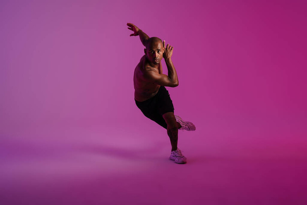 Image of a handsome strong african fitness sports man runner isolated over pink wall background - Foto, immagini