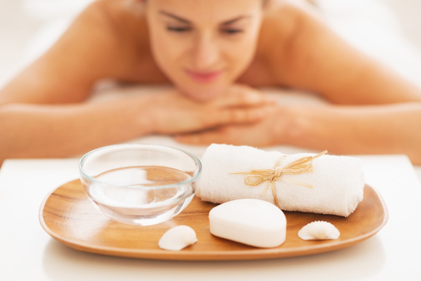 Closeup on spa therapy ingredients and relaxed young woman in background - Photo, Image