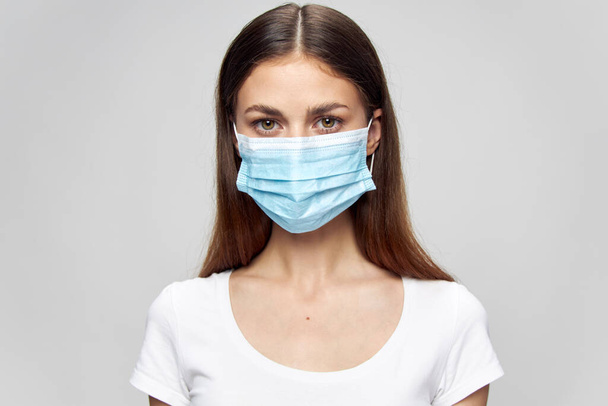 Portrait of a woman Medical face mask look ahead white t-shirt  - Foto, Bild