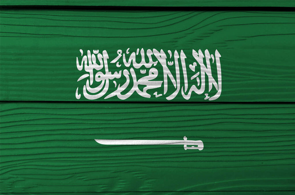 Saudi-Arabian lippu puinen seinä tausta. Grunge Saudi-Arabia lippu rakenne, vihreä kenttä Shahada tai muslimi uskontunnustus kirjoitettu Thuluth käsikirjoituksen valkoinen yläpuolella vaakasuora sapeli. - Valokuva, kuva