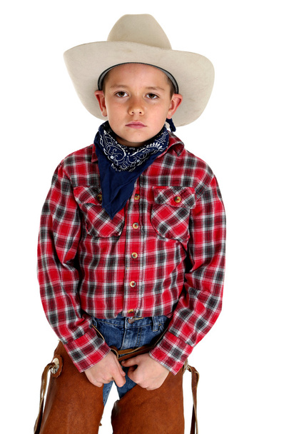 Young cowboy with a serious look peering at camera - Фото, изображение