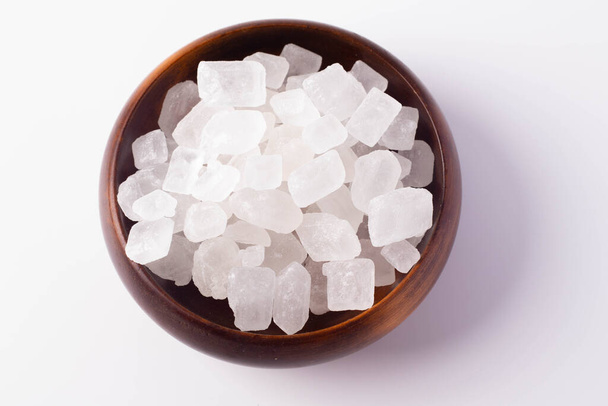 Белый рок сахар в деревянной чашке на белом фоне - Фото, изображение