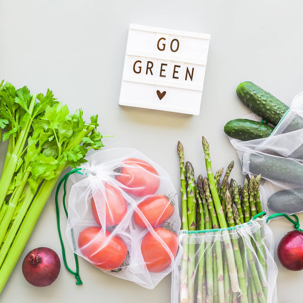 エコ再利用可能な新鮮な有機野菜は、テキストゴーグリーン、グレーの背景とショッピングバッグフラットレイアウト、トップビューとライトボックスを生成します。持続可能なライフスタイル。廃棄物ゼロ、プラスチックフリーコンセプト. - 写真・画像