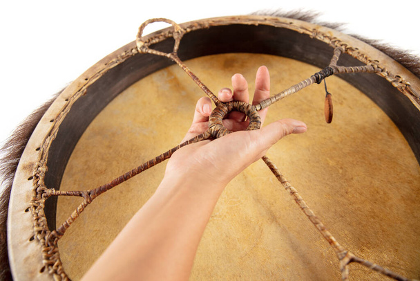 A close up of hands playing the tambourine, percussion on white studio background - Fotó, kép