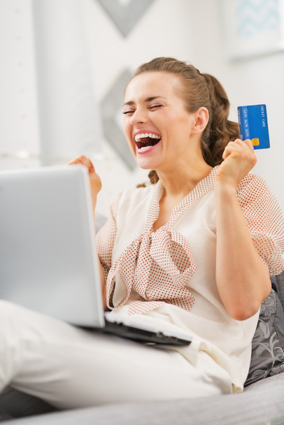 Happy young woman with credit card and laptop rejoicing - Fotoğraf, Görsel