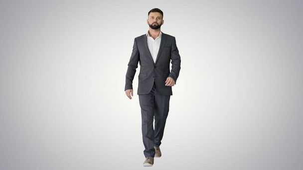 Serious businessman with a beard and in formal suit walking on g - Foto, Imagen