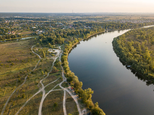 Vue aérienne sur drone. Le virage d'une large rivière parmi les prairies verdoyantes. Journée ensoleillée d'été. - Photo, image