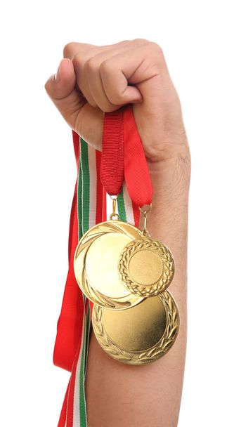 Man holding golden medals on white background, closeup. Space for design - Fotó, kép