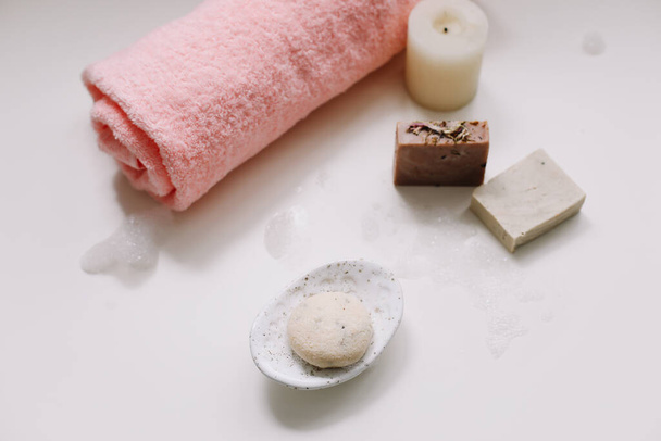 Spa set. Bar of handmade soap, candle and towel. Accessories for personal hygiene. Decor for bathroom interior - Photo, Image