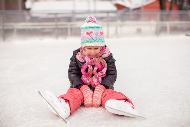 Niña triste sentada en una pista de patinaje después de la caída
 - Foto, Imagen