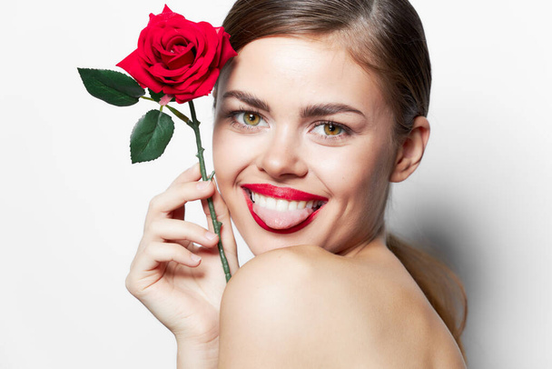 Κυρία με τριαντάφυλλο Δείχνει γλώσσα χαμόγελο γυμνοί ώμοι γοητεία φως  - Φωτογραφία, εικόνα