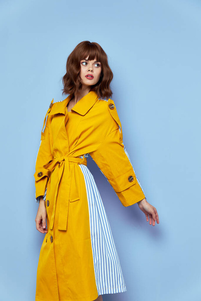 mulher de casaco amarelo com botões olha para o lado  - Foto, Imagem