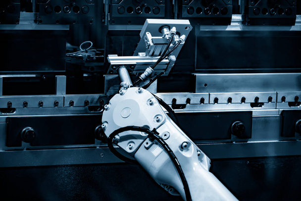 Il funzionamento del braccio robotico presso la piegatrice idraulica. Il processo di formatura della lamiera ad alta tecnologia tramite sistema robotico. - Foto, immagini