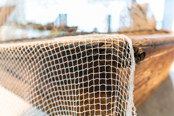 Nahaufnahme eines Fischernetzes auf einem Dhau-Boot im Nahen Osten, das historisch für Transport und Fischfang genutzt wurde. - Foto, Bild