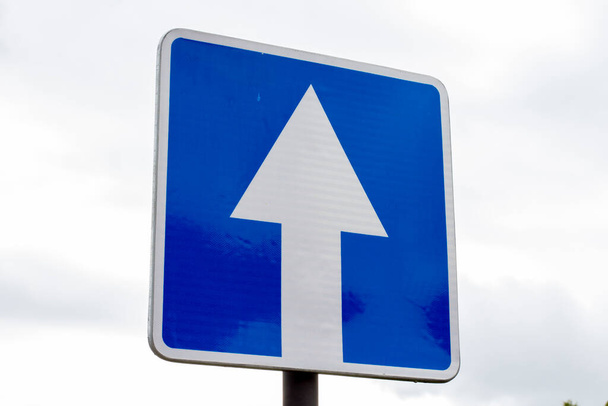 One way road sign on cloudy sky background, close-up. - Foto, imagen