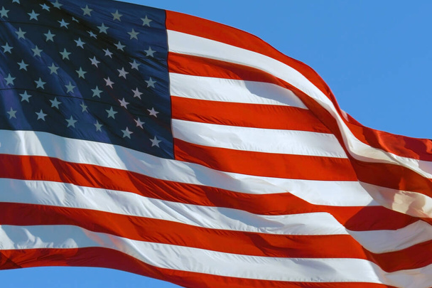 閉じる:アメリカの国旗が風になびく。現実的なアメリカ国旗の背景。アメリカ国旗。非常に詳細な生地のテクスチャを織り。晴れた日にアメリカ国旗が風になびく - 写真・画像