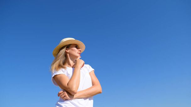 Vista inferiore di una giovane ragazza con un cappello contro un cielo blu - Foto, immagini