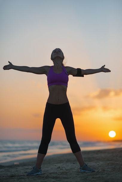 Silhouette de fitness jeune femme se réjouissant sur la plage au crépuscule
 - Photo, image