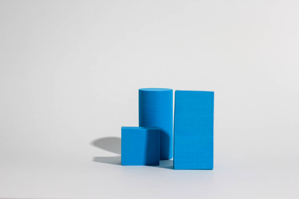 Stack of blue blocks. Geometrical figures still life composition. Platonic solids figures, simplicity concept photography. Blue rectangles and cylinders. - Photo, Image