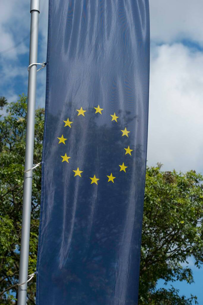Flaga Unii Europejskiej, niebieska flaga z żółtymi gwiazdami reprezentującymi UE - Zdjęcie, obraz