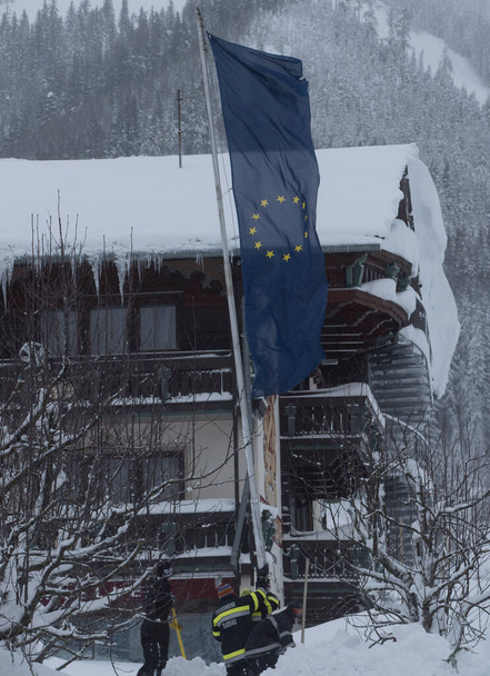 Σημαία της Ευρωπαϊκής Ένωσης το χειμώνα, γαλάζια σημαία με κίτρινα αστέρια που αντιπροσωπεύουν την ΕΕ - Φωτογραφία, εικόνα