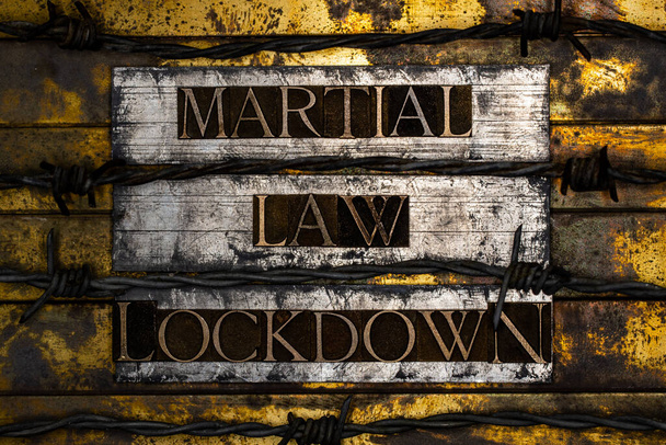 Martial Law Lockdown szöveg alakult valódi hiteles betűtípus betűk szögesdrót vintage texturált ezüst grunge réz és arany háttér - Fotó, kép