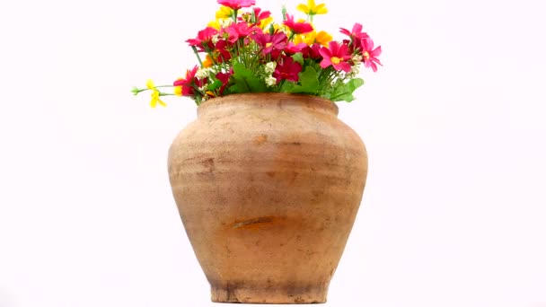 Clay vase with a bouquet of flowers on a white background. Ceramic clay jug on a white background. Bouquet of flowers. Ceramic pot. Old kitchen utensils. Handmade clay jug. White background. Video. - Footage, Video