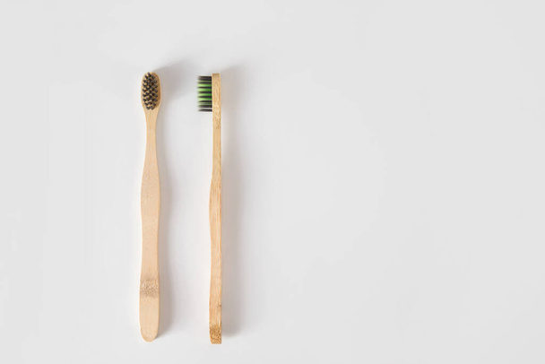 Two toothbrushes made of natural materials on white with copy space. Zero waste. concept. Flat lay. Hygiene supplies - Foto, Bild