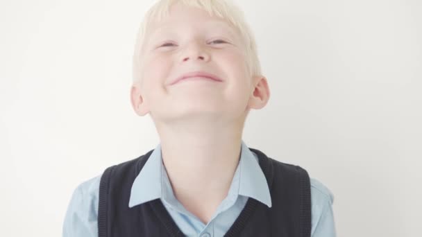 Een close-up van een jongen in een schooluniform tegen een stralende achtergrond - Video
