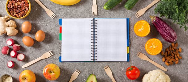 Conceito de dieta e alimentação saudável. Bloco de notas com um cronograma de alimentos e alimentos saudáveis, legumes, frutas, verduras, nozes, ovos, legumes. vista superior - Foto, Imagem