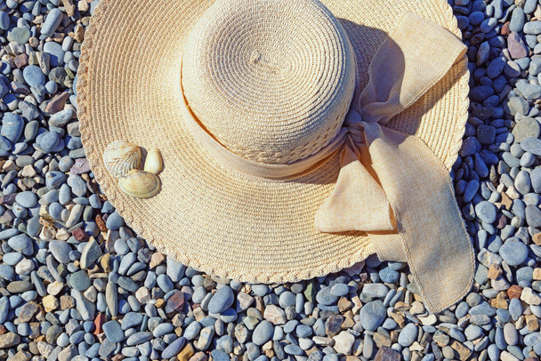 Concepto de vacaciones. Sombrero de sol en la playa de guijarros en día soleado - Foto, imagen