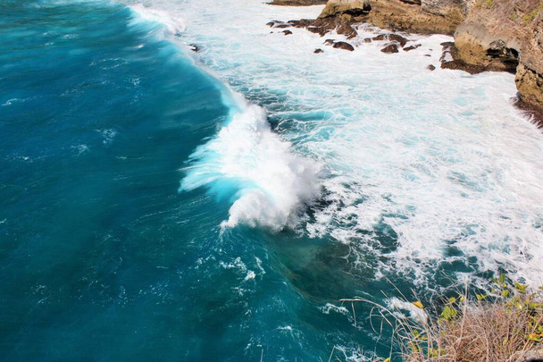 Волны, разбивающиеся возле скал в красивой голубой воде, Нуса Пенида, Индонезия - Фото, изображение
