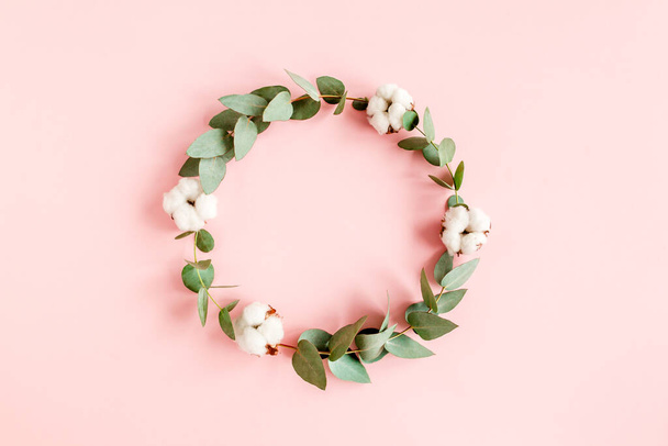 Flowers composition, wreath made of branches eucalyptus, leaves and cotton isolated on pink background.flat lay, top view. floral concept - Foto, immagini