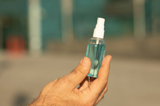 Close view of person holding antiseptic in hand - Φωτογραφία, εικόνα