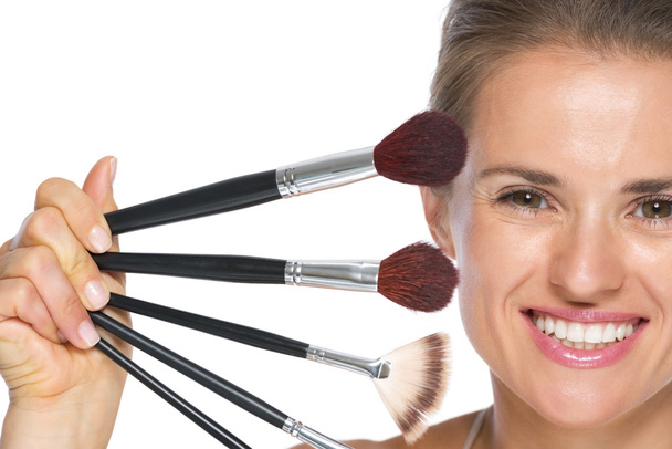 Young woman showing makeup brushes - Photo, Image