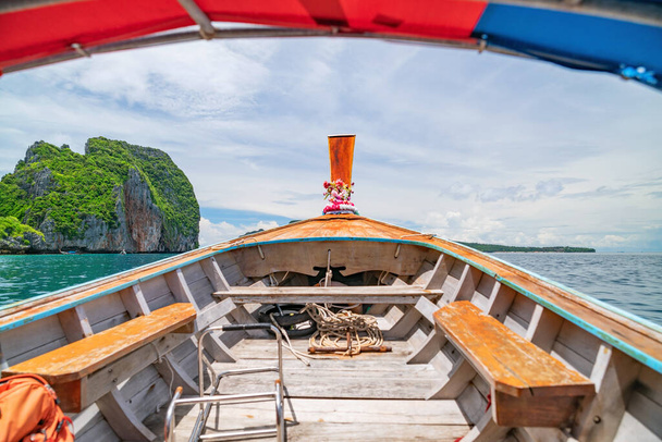 Traditionelles hölzernes Langschwanzboot gegen steile Kalksteinhügel in der Phi Phi Insel Krabi Provinz Thailand  - Foto, Bild