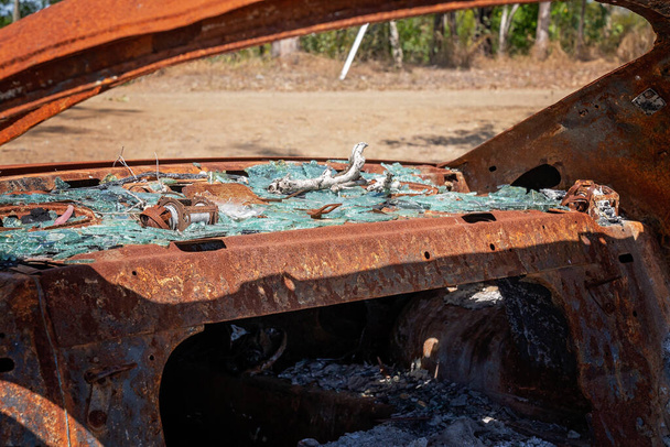 Close up of the interior of a rusting burnt out car wreck left abandoned in the bush - Photo, Image