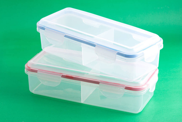 Mehrzweck-Kunststoffbehälter mit luftdichtem Deckel; Foto auf grünem Hintergrund. - Foto, Bild