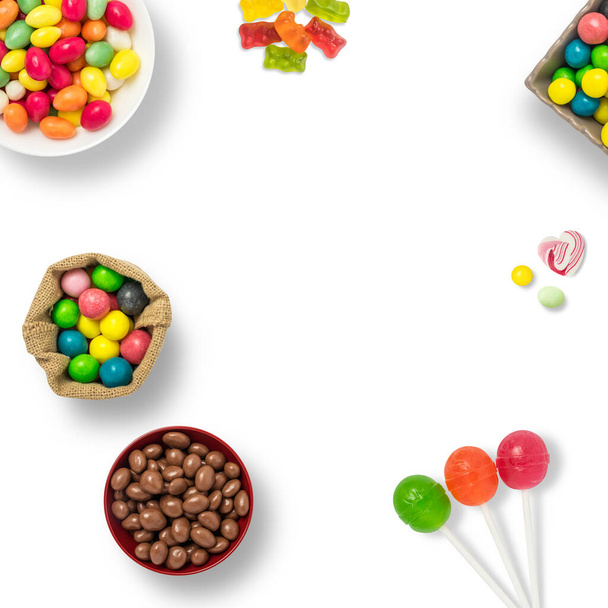 コピースペースのある白い背景にキャンディ、チョコレート、ロリポップ。背景には、お菓子とバナーを背景に。カラフルなお菓子のトップビュー. - 写真・画像