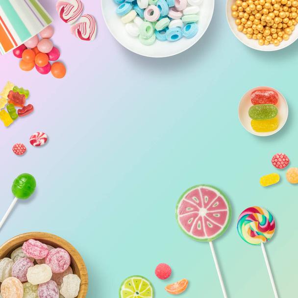 Candies, chocolates and lollipops on a light blue background with copy space. Backdrop, banner o background with sweets. Top view of colorful sweets. - Photo, Image