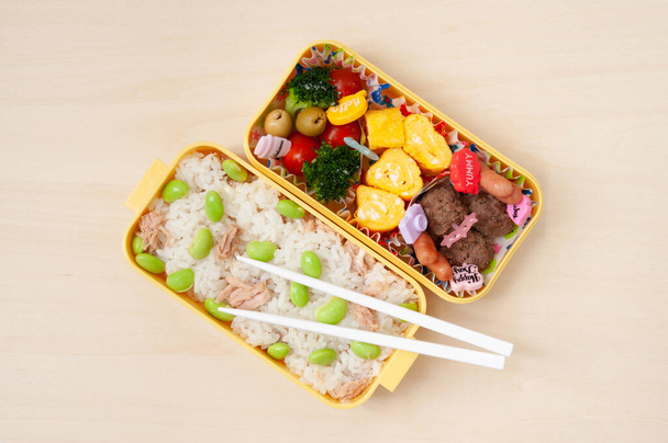 Японская кухня - Top view of traditional homemade Bento box with rice, meat, egg, fish, vegetables and grains. Для детей, чтобы взять в школу.  - Фото, изображение